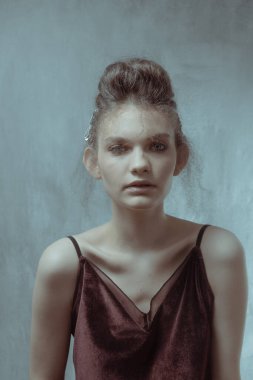 Saçları ve makyajı olan güzel bir kızın geçmişe dönük portresi.