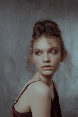 Saçları ve makyajı olan güzel bir kızın geçmişe dönük portresi.