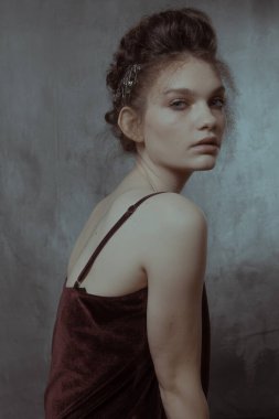 Saçları ve makyajı olan güzel bir kızın geçmişe dönük portresi.