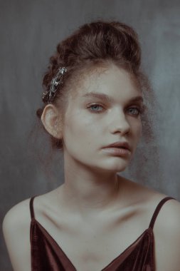 Saçları ve makyajı olan güzel bir kızın geçmişe dönük portresi.