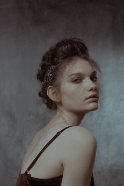 Saçları ve makyajı olan güzel bir kızın geçmişe dönük portresi.