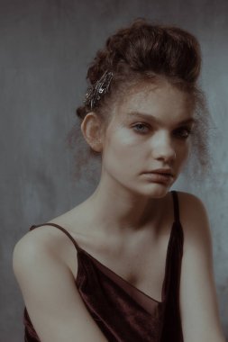 Saçları ve makyajı olan güzel bir kızın geçmişe dönük portresi.