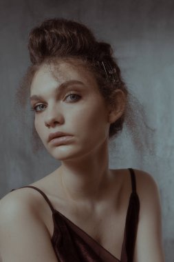 Saçları ve makyajı olan güzel bir kızın geçmişe dönük portresi.