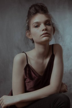 Saçları ve makyajı olan güzel bir kızın geçmişe dönük portresi.