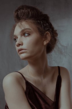 Saçları ve makyajı olan güzel bir kızın geçmişe dönük portresi.