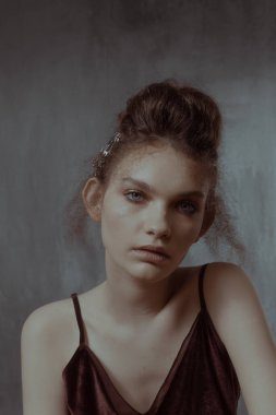 Saçları ve makyajı olan güzel bir kızın geçmişe dönük portresi.