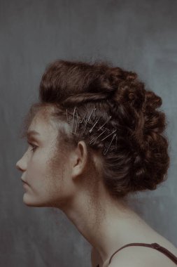 Saçları ve makyajı olan güzel bir kızın geçmişe dönük portresi.