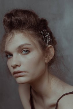 Saçları ve makyajı olan güzel bir kızın geçmişe dönük portresi.