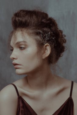 Saçları ve makyajı olan güzel bir kızın geçmişe dönük portresi.