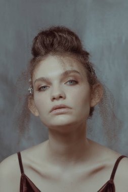 Saçları ve makyajı olan güzel bir kızın geçmişe dönük portresi.