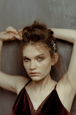 Saçları ve makyajı olan güzel bir kızın geçmişe dönük portresi.