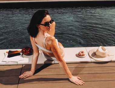 Yazın havuz kenarında mayo giymiş güzel bir kız. 