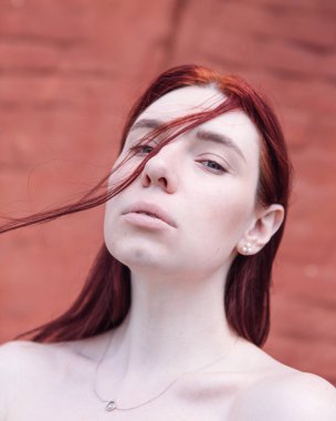 Parlak, makyajsız kızıl saçlı bir kızın yaz portresi.