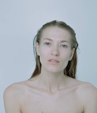 Açık arkaplanda güzel bir kızın açık renk portresi, saç ve makyajlı.