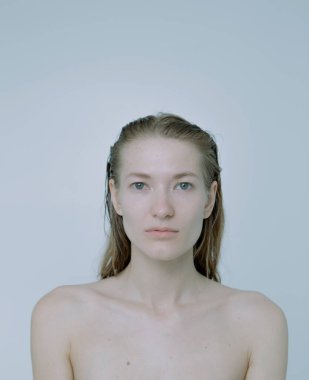 Açık arkaplanda güzel bir kızın açık renk portresi, saç ve makyajlı.