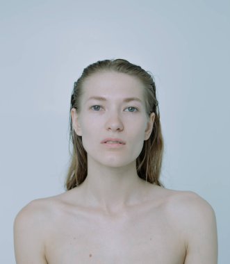 Açık arkaplanda güzel bir kızın açık renk portresi, saç ve makyajlı.