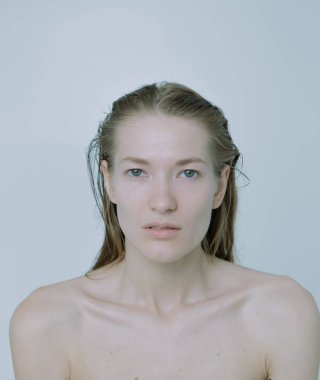 Açık arkaplanda güzel bir kızın açık renk portresi, saç ve makyajlı.