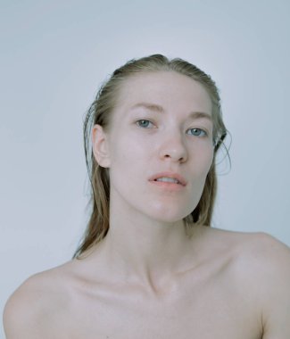 Açık arkaplanda güzel bir kızın açık renk portresi, saç ve makyajlı.