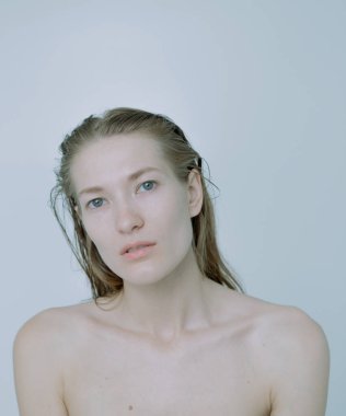 Açık arkaplanda güzel bir kızın açık renk portresi, saç ve makyajlı.