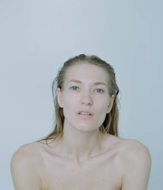 Açık arkaplanda güzel bir kızın açık renk portresi, saç ve makyajlı.