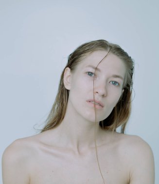 Açık arkaplanda güzel bir kızın açık renk portresi, saç ve makyajlı.