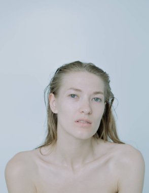 Açık arkaplanda güzel bir kızın açık renk portresi, saç ve makyajlı.