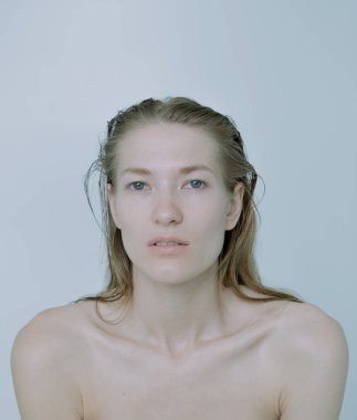 Açık arkaplanda güzel bir kızın açık renk portresi, saç ve makyajlı.