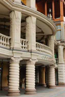 İyi korunmuş bir parkta balkonları ve merdivenleri olan güzel bir mimari. Bir sürü çiçek ve yeşillik.