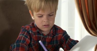 Şirin Çocuk Evde Uzaklık Çalışması Öğreniyor. Anaokulu çocuğu 4K no 'lu odanın yanındaki masada oturuyor.