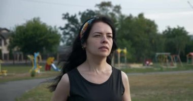 Güzel genç kadın sabah egzersizi yaparak koşuyor. Güzel Kız Formda Kadın Sporcu. Kenar mahallelerde futbol sahası var. Yaz Günü 4K
