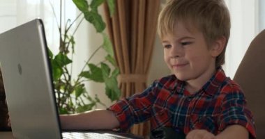 Bilgisayar kullanarak Çocuk Çalışmaları Çevrimiçi Ders Video Konferansı Sohbeti. Evde Çocuk Mesafesi Öğrenme. Anaokulu çocuğu 4K no 'lu odanın yanındaki masada oturuyor.