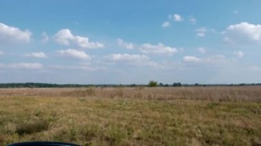 Ovaların Üzerinde Mavi Gökyüzü Manzarası. Araba penceresinden yan görüş. Off-road 'a git. Kırsal Kır Sahnesi 4K