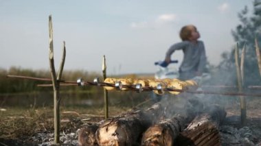Kamp ateşinde Şiş 'te Patates Kızartması. Aile Çocuk Gezisi Piknik Pikniği Kırsal Bölge 'de. Doğanın Kırsal Sahne Yaz Günü. 2x Yavaş çekim 60fps 4K