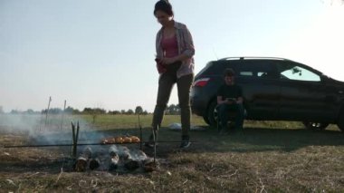 Şiş 'te Patates Kızartmalı Ebeveynler Ateş Kampı' nda Aşçı Yemeği Hazırlayın. Kırsal bölgedeki Family Outing Piknik Pikniği. Doğanın Kırsal Sahne Yaz Günü. 2x Yavaş çekim 60fps 4K