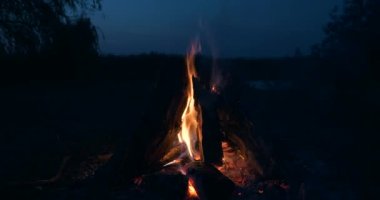 Saha Ovası 'ndaki Kamp Alanı' nda yakın çekim Yakıcı Odun Ateşi Kamp Ateşi. Kırsal Kır Sahnesi. Yaz Akşamı Alacakaranlık Gecesi 4K