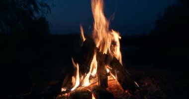Saha Ovası 'ndaki Kamp Alanı' nda yakın çekim Yakıcı Odun Ateşi Kamp Ateşi. Kırsal Kır Sahnesi. Yaz Akşamı Alacakaranlık Gecesi 4K