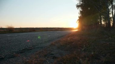 Asphalt Yolu 'na yakın otoban yakınlarında. Sonbahar sezonu. Akşam Günbatımı Günışığı. Avrupa Kırsal Sahne Arkaplanı. 2x Yavaş çekim 60fps 4K