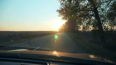 Sürücü POV ön cam aracı ön ekran araba kaputu. Autumn Evening Sunset Highway Country Road Pled Field yakınlarında. 2x Yavaş çekim 60fps 4K