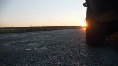 Otoyol kenarındaki asfalt yolda, Asphalt Tarlası 'na yakın bir yerde araç durdurma tehlikesi var. Sonbahar sezonu. Akşam Günbatımı Günışığı. Avrupa Kırsal Sahne Arkaplanı. 2x Yavaş çekim 60fps 4K