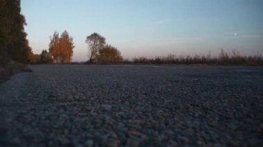 Akşam Karayolu Alacakaranlık Tarlası yakınlarında. Asphalt Road Country Sonbahar sezonuna yakın çekim. İyi akşamlar Sabah. Avrupa Kırsal Sahne Arkaplanı. 2x Yavaş çekim 60fps 4K
