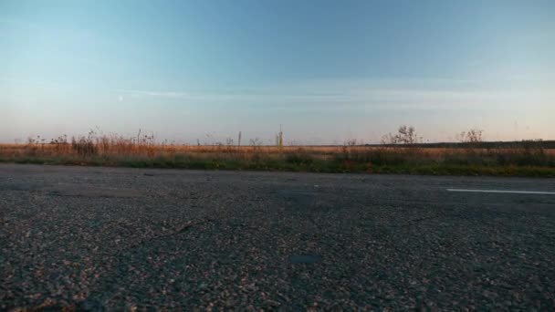 高速道路に沿って移動車アスファルトカントリーロード近くフィールド 秋の季節 夕日の日差し ヨーロッパ農村風景背景 2倍スローモーション60Fps — ストック動画