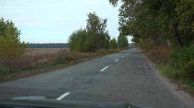 Sürücü POV ön cam aracı ön ekran araba kaputu. Kırsal Otoyol Köyü. Sonbahar Bulutlu Günü. 2x Yavaş çekim 60 fps 4K