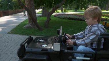 Happy Child Park 'ta Elektrikli Oyuncak Araba Sürüşü Yapıyor. Heyecanlı Çocuk 'u eğlendirdim. Yaz sabahı güneşli bir gün. 2x Yavaş çekim 60 fps 4K