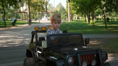 Happy Child Park 'ta Elektrikli Oyuncak Araba Sürüşü Yapıyor. Heyecanlı Çocuk 'u eğlendirdim. Yaz sabahı güneşli bir gün. 2x Yavaş çekim 60 fps 4K
