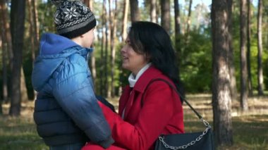 Genç Sevecen Anne Oğlu Çocukla Konuşuyor. Kadın, Çocukla Park 'ta Dinlen. Güneşli bir gün. 2x Yavaş çekim 60fps 4K