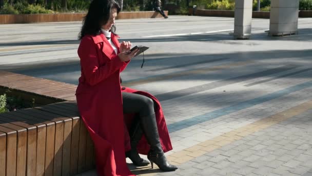 在城市公园里 妇女用智能手机在电话上浏览互联网 严肃的女性面孔 秋日2X慢动作60Fps — 图库视频影像
