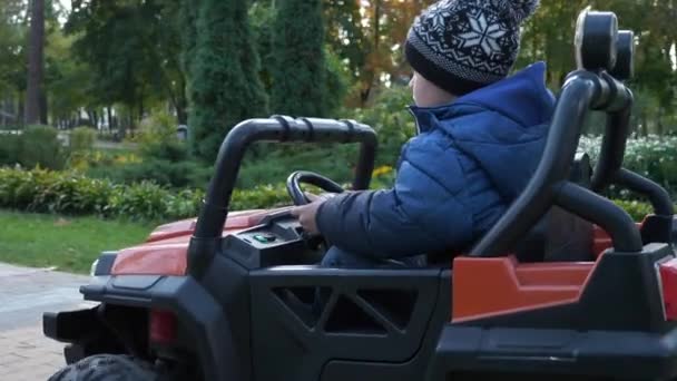 Leuke Kid Drives Elektrische Aangedreven Speelgoed Auto Rijden Park Amusant — Stockvideo