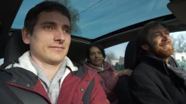 Mutlu Arkadaşlar Arabayla Birlikte Seyahat Eder. Bir grup Turist Aile Seyahati. SUV Panoramik Cam Çatı. Erkek Kadın Kış Giyimi Sonbahar Sezonu. 2x Yavaş çekim 60fps 4K