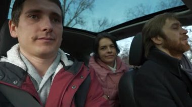 Mutlu Arkadaşlar Arabayla Birlikte Seyahat Eder. Bir grup Turist Aile Seyahati. SUV Panoramik Cam Çatı. Erkek Kadın Kış Giyimi Sonbahar Sezonu. 2x Yavaş çekim 60fps 4K
