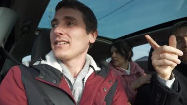 Mutlu Arkadaşlar Arabayla Birlikte Seyahat Eder. Bir grup Turist Aile Seyahati. SUV Panoramik Cam Çatı. Erkek Kadın Kış Giyimi Sonbahar Sezonu. 2x Yavaş çekim 60fps 4K